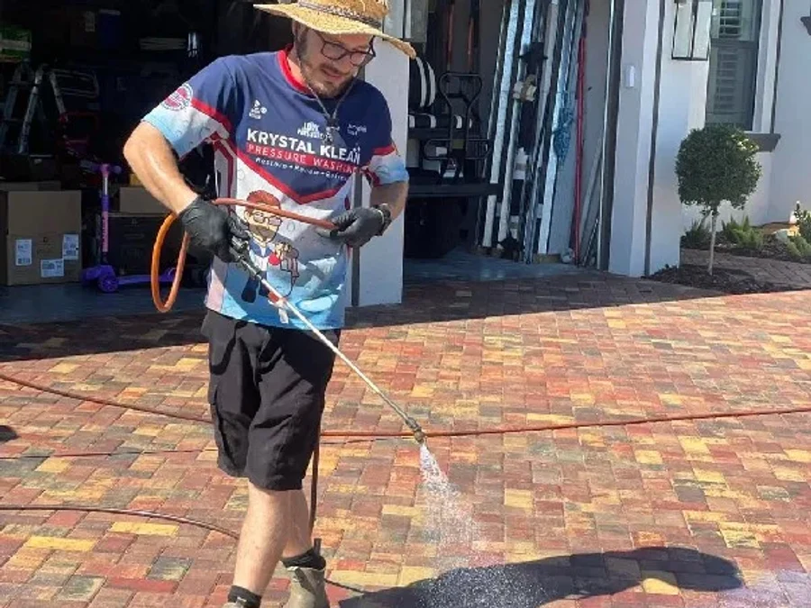 Technician applying paver sealer after preparation