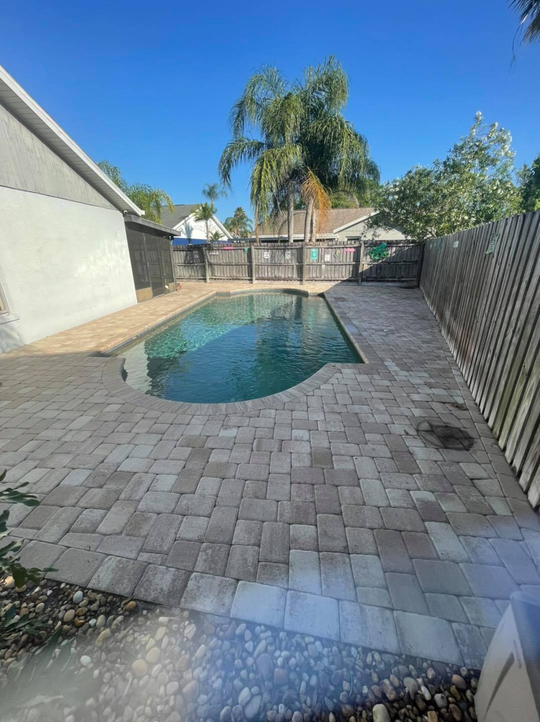 Paver pool deck before cleaning, stained and faded
