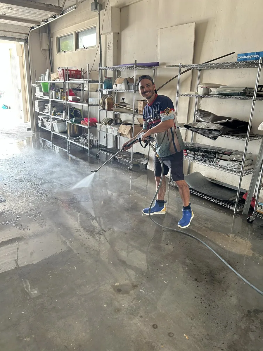 Krystal Klean tech washing storm mud out of a condo garage